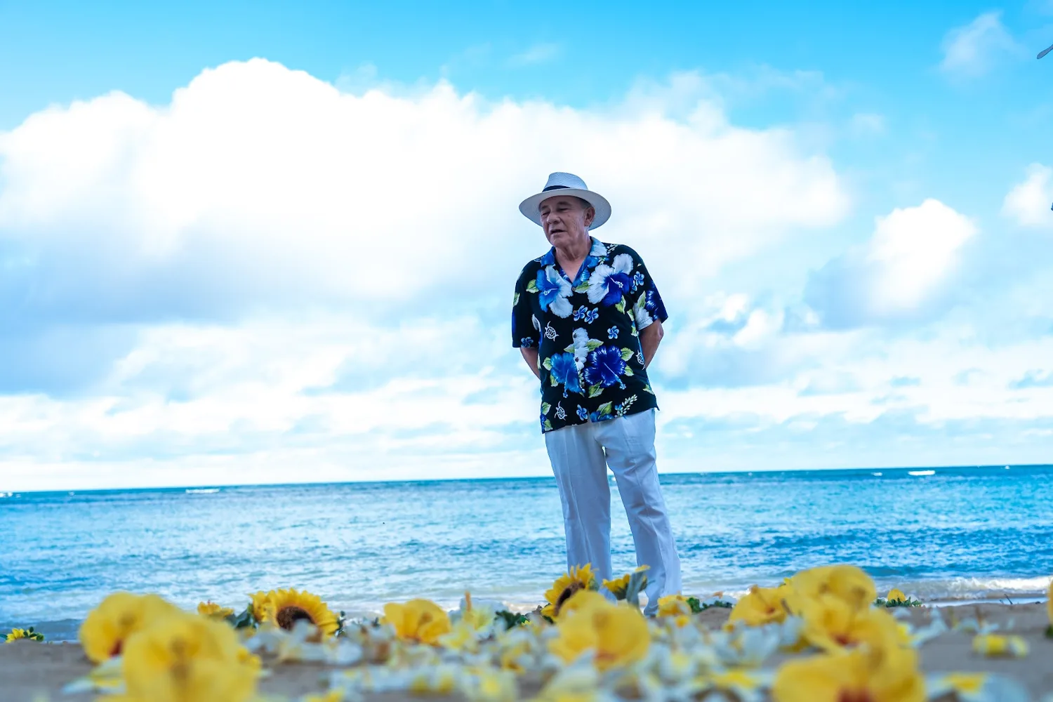 Daniel waiting on the beach by the yellow plumeria petals