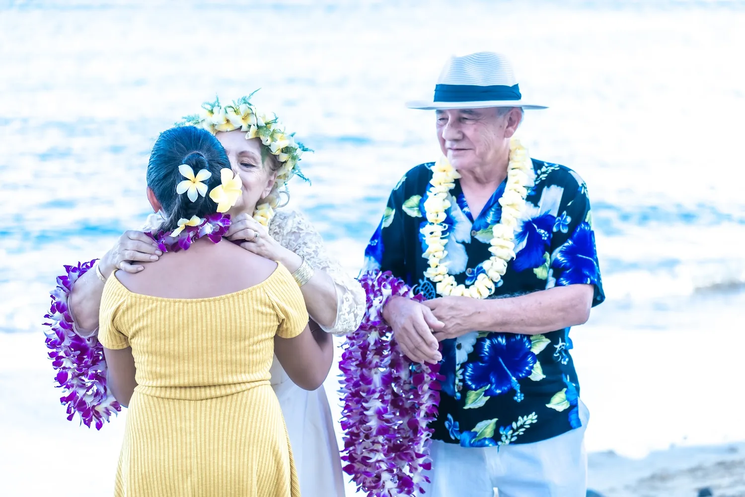 Daniel with a family member in yellow and their leis