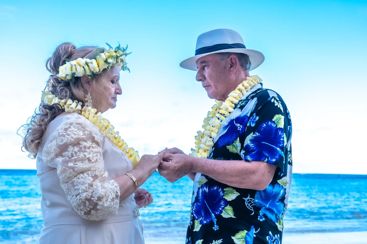 Holding hands in their yellow leis