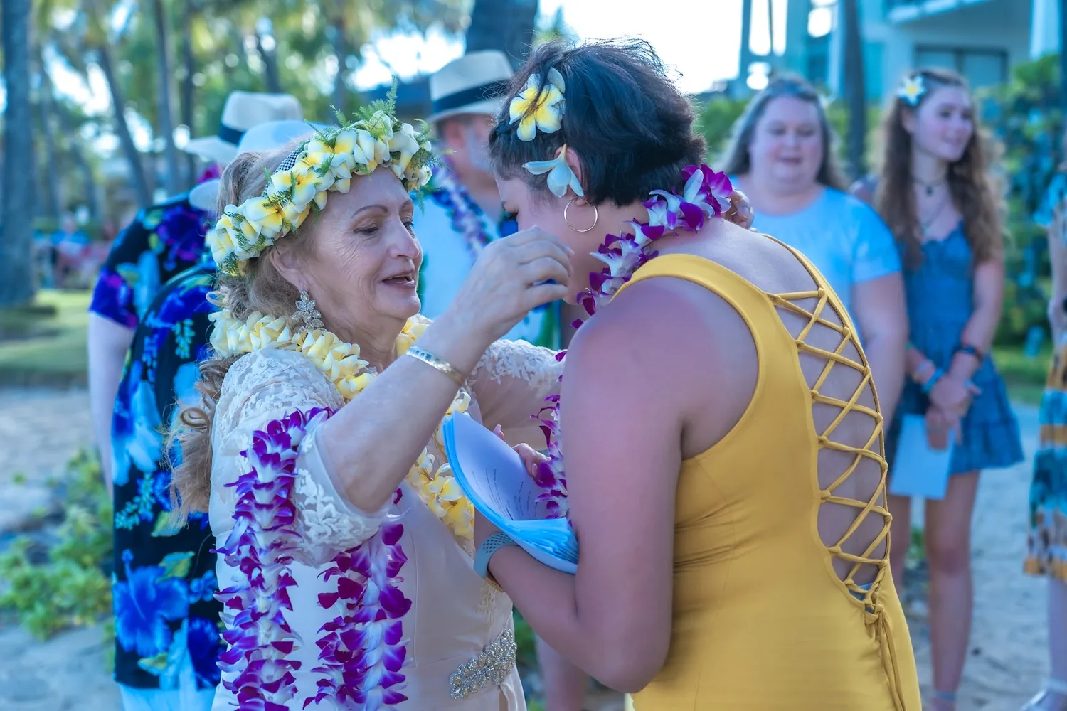 Shirley hugging a family member in a purple lei