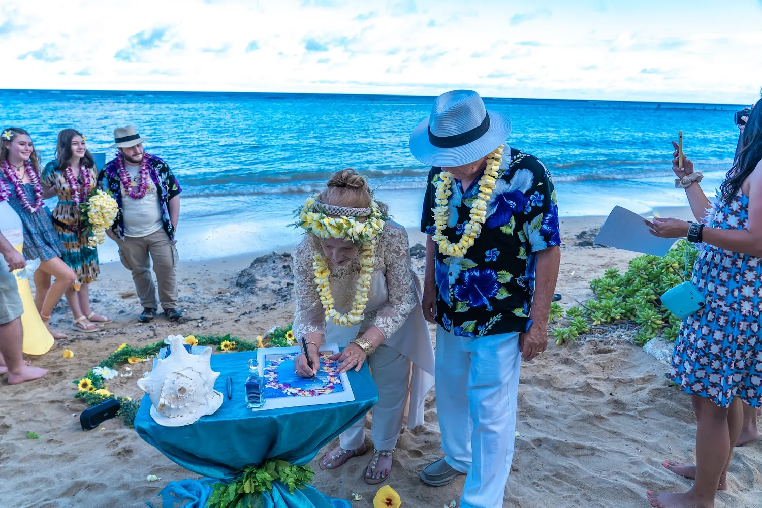 Signing the vow renewal certificate on the beach