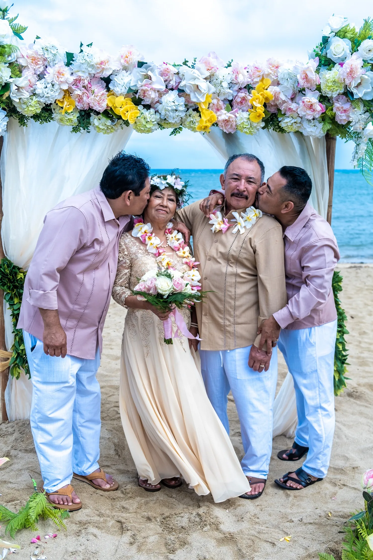 Two family members kissing her cheeks as she holds her bouquet