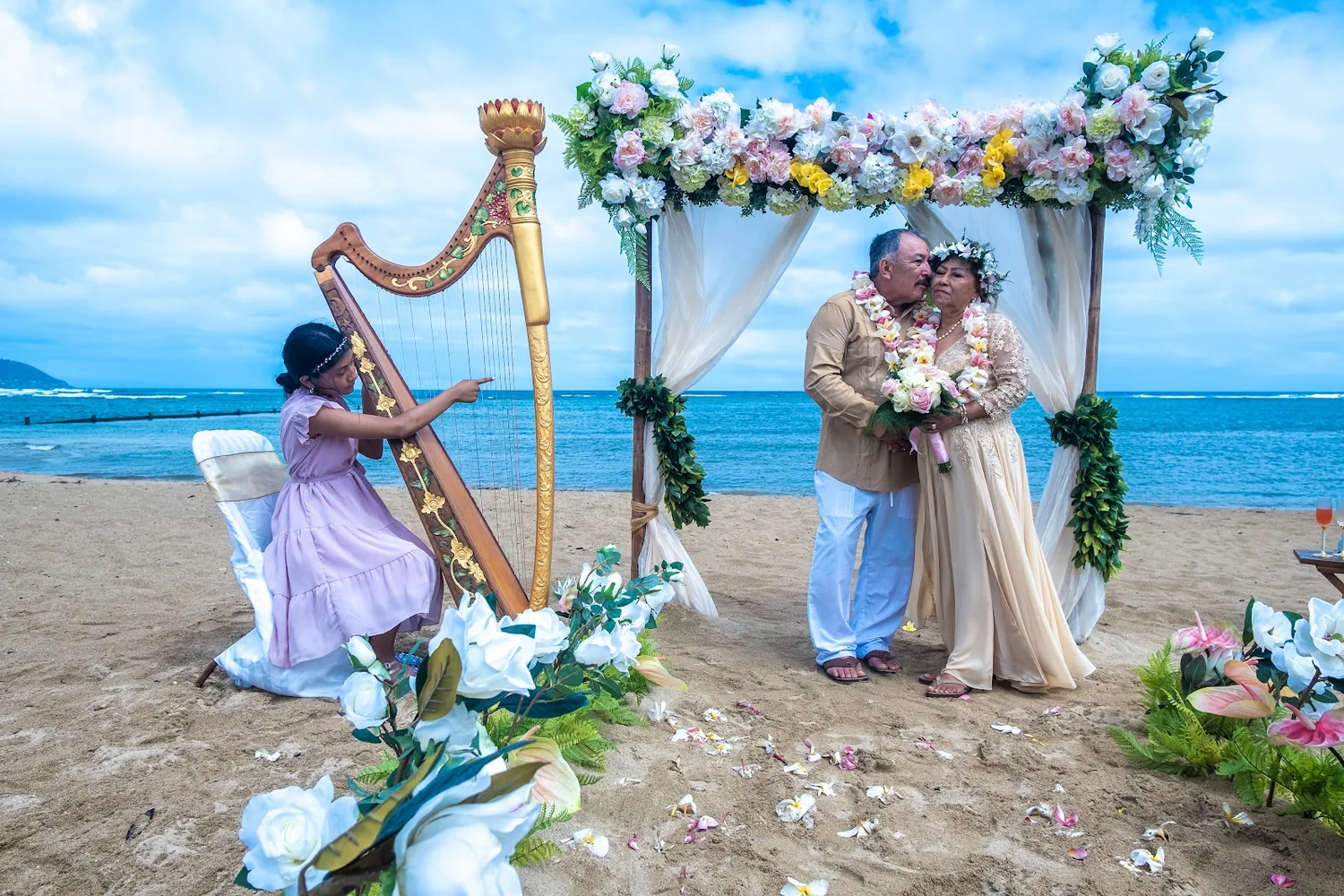 The golden harp playing on the sand beside the flower arch