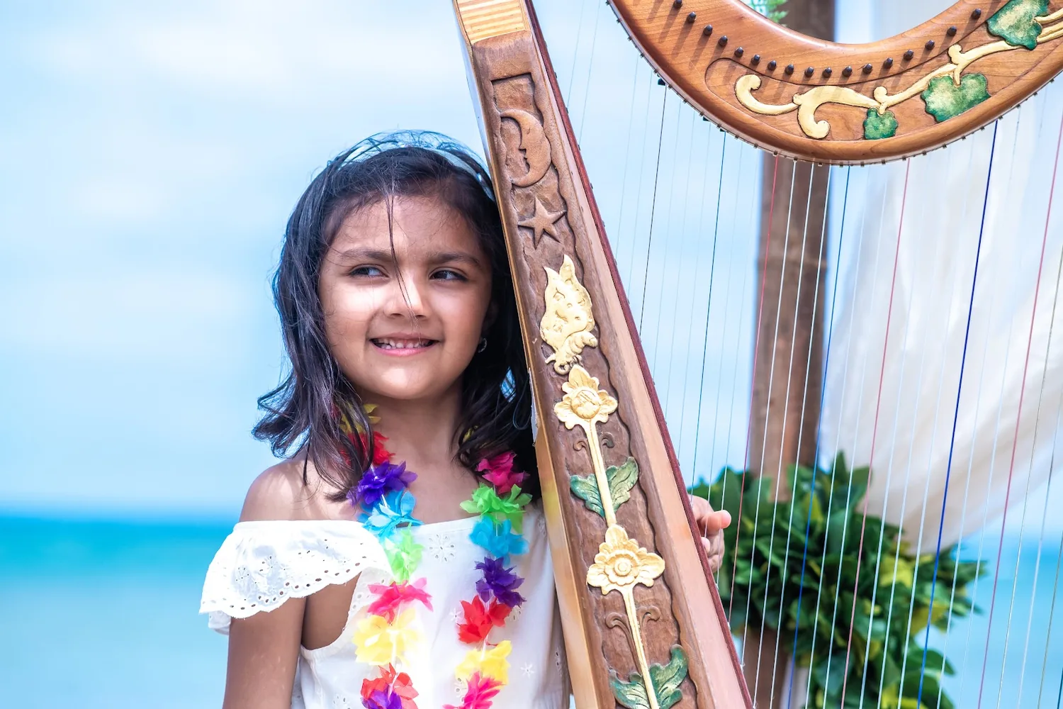 A granddaughter in a flower crown beside the golden harp