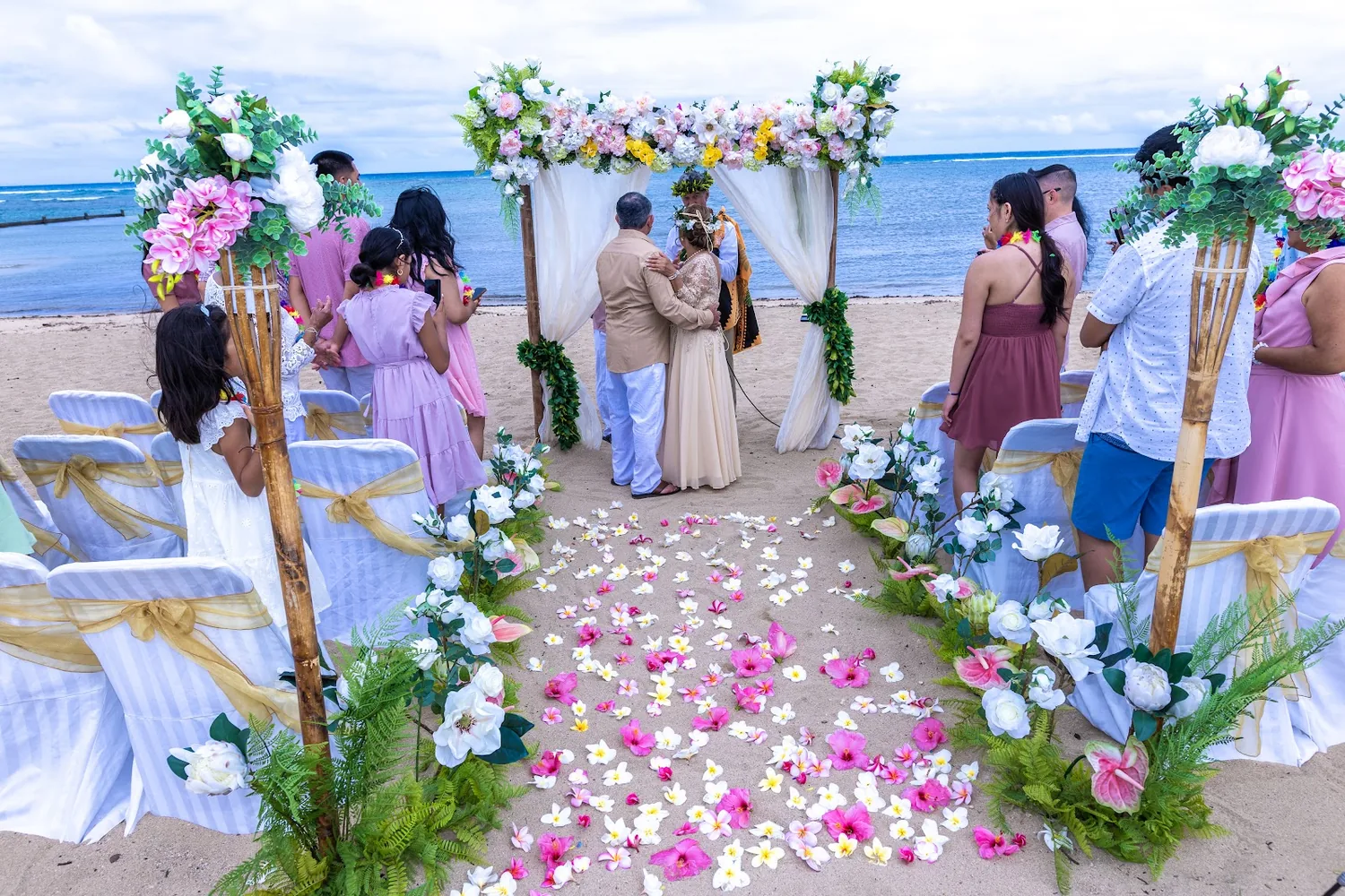 Guests in lavender watching as the couple reaches the arch