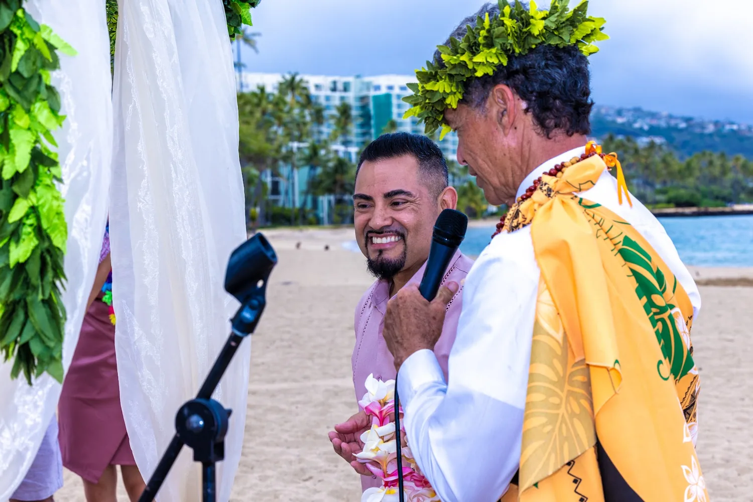The kahu in a yellow kihei giving a Hawaiian blessing