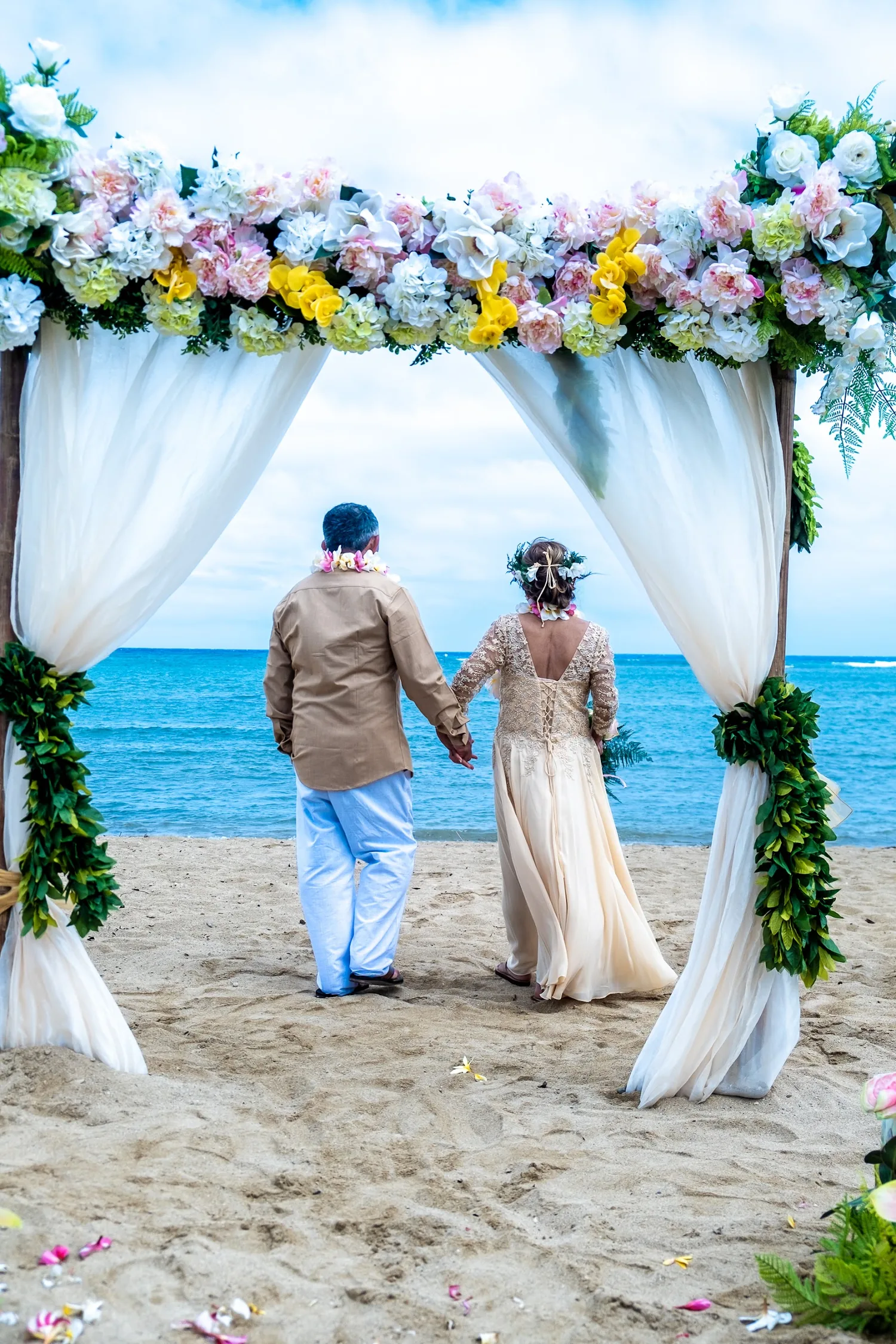 Walking hand in hand toward the sea through the white curtains