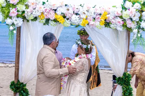 The Hawaiian blessing under the flower arch by the sea