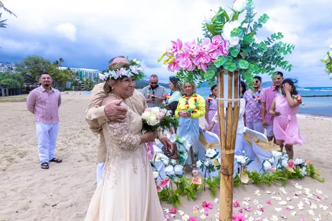 The wife arriving at the aisle beside a pink and white flower stand