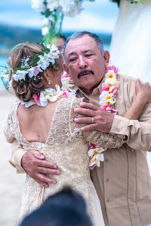 Close up of the couple in leis and her flower crown