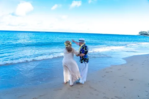 Daniel and Shirley walking hand in hand on the sand
