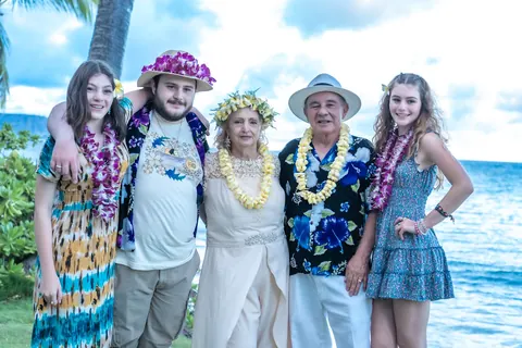 Family in leis by the ocean