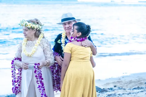 Family in leis by the water
