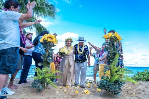Guests standing by the sunflowers on the beach