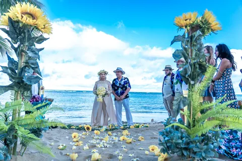 Sunflowers framing the couple and the ceremony on the sand