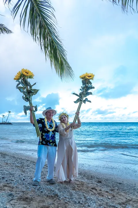 The couple between the sunflowers with the ocean behind