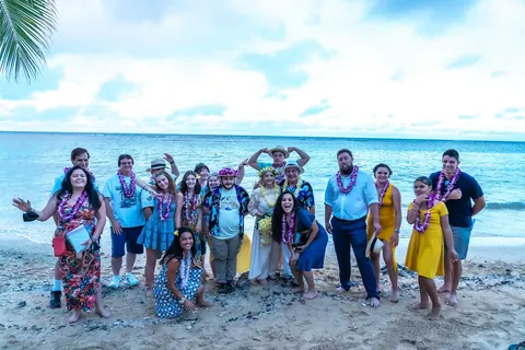 The whole group in leis on the sand