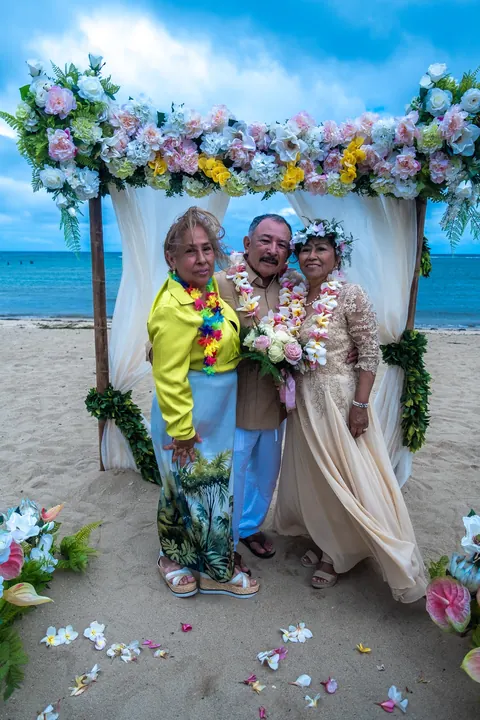 A family member in yellow celebrating with the couple