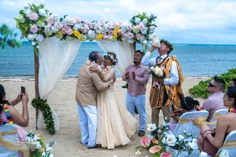 The officiant speaking to the couple under the arch
