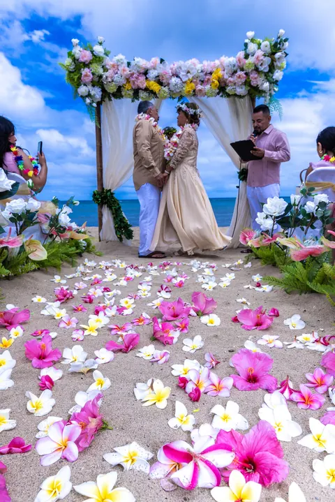 The couple walking up the pink and white petal aisle