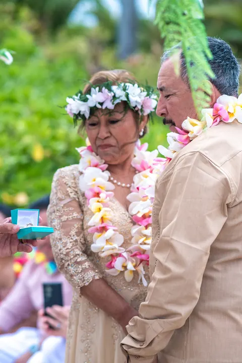 Close up of the couple in their leis with the ring box