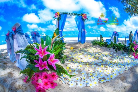 Ocean blue archway with plumerias and stargazer lilies on the sand
