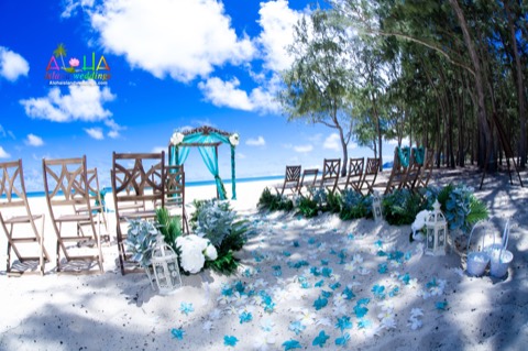 Hand carved koa archway with dark walnut chairs and white and turquoise orchids
