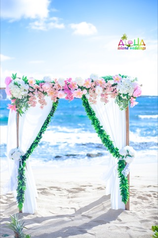 A white archway draped with maile leaves