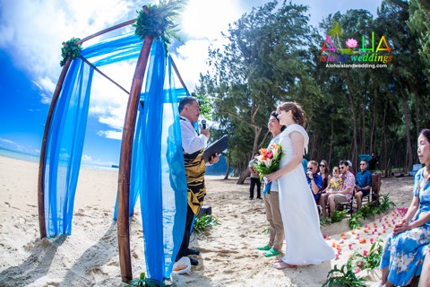 Pastor John welcomes Toshi and Suzanne under the blue archway