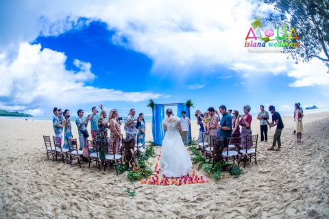 Suzanne walks down the sandy aisle as the guests stand at her Waimanalo beach wedding