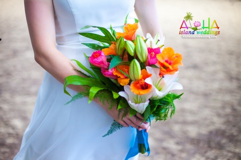 Suzanne holds her bouquet of white lilies with orange and pink hibiscus