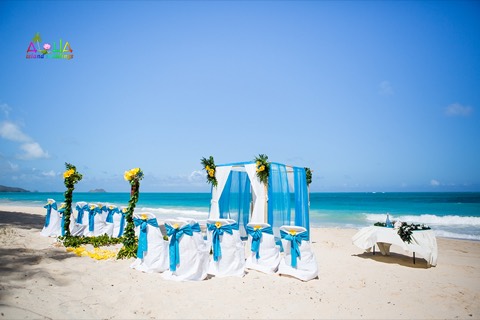 White chairs with turquoise sashes and a draped arch facing Rabbit Island