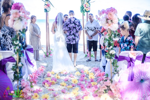 The bride walks up the flower lined aisle to renew her vows