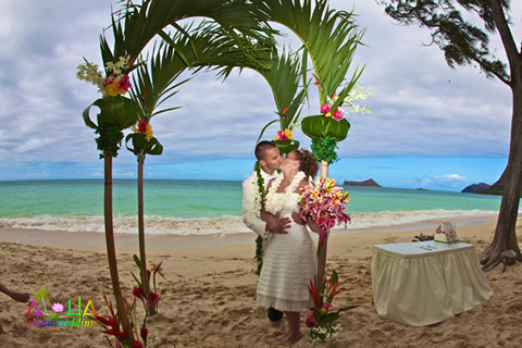 Alone on the beach together for a kiss under the arch