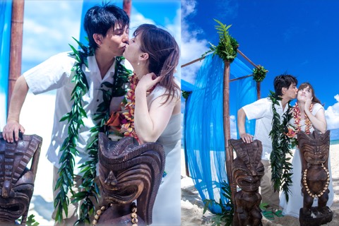 Toshi and Suzanne kiss beside a carved tiki man in their flower leis
