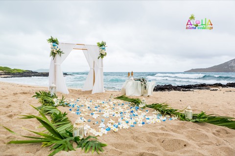 Pink and yellow flowers and candles lining the aisle to the arch