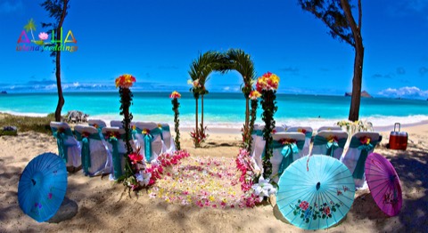Bridesmaids with parasols along the aisle to the palm archway