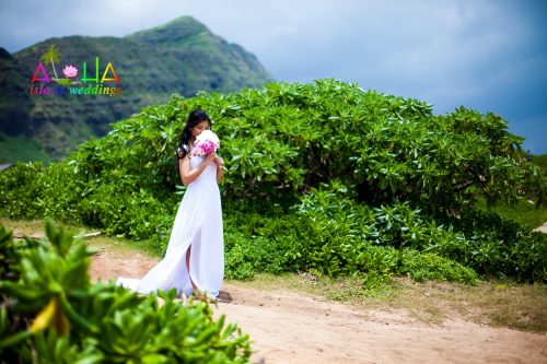 Bride walks with her bouquet down the sandy aisle way of love at this beach wedding in hawaii