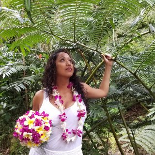 Bride in the forest with her yellow and purple orchid flowers