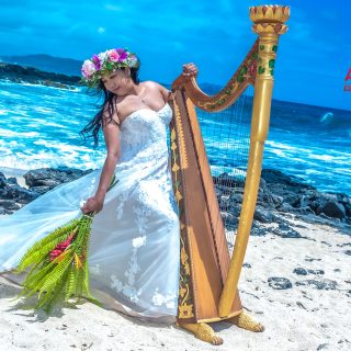 Dewi playing the harp on the beach