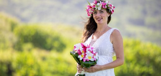 Petra in a pink and white plumeria haku lei holding a plumeria bouquet at her Oahu wedding